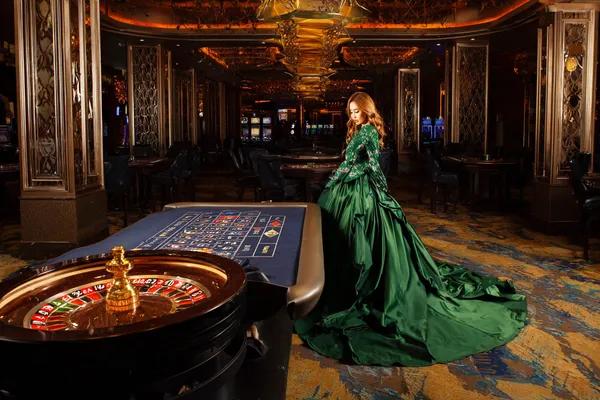 A young woman relaxing with her phone while dynamic casino elements float around her, illustrating the smooth mobile experience offered by the OKTA app.