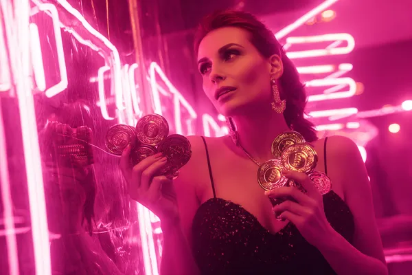 A glamorous woman holding casino chips in a neon-lit environment, representing the premium online casino atmosphere of OKTA.
