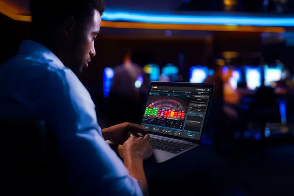 A close-up shot of golden coins falling around a spinning roulette wheel, representing immersive casino action at OKTA.