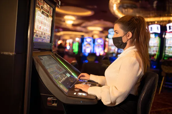 OKTA Mobile Casino — Play anytime, anywhere A player using their smartphone during a festive local event, representing OKTA’s fully mobile-friendly casino.